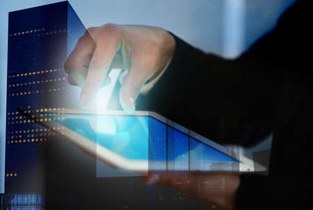 Concept of consulting. Double exposure of cityscape and man using tabletの写真素材