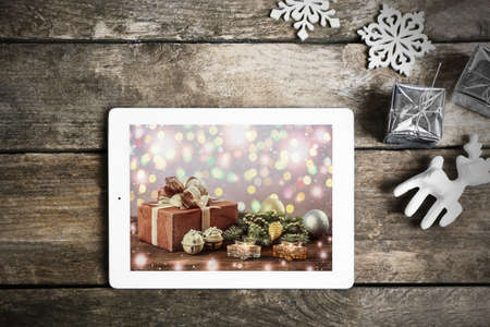 Tablet and festive decor on wooden background. Boxing day conceptの写真素材