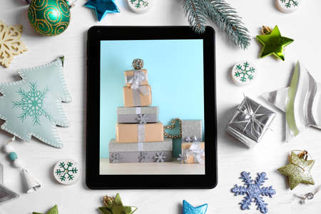 Tablet and festive decor on white wooden background. Boxing day conceptの写真素材
