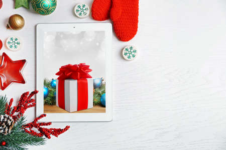 Tablet and festive decor on white wooden background. Boxing day conceptの写真素材