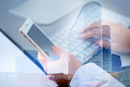 Concept of consulting. Double exposure of cityscape and woman using smartphoneの写真素材