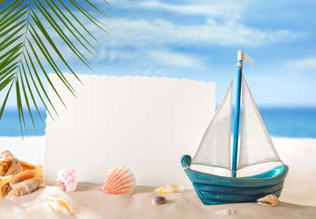 Blank card with sea shells and toy boat on beach. Summer vacation conceptの写真素材