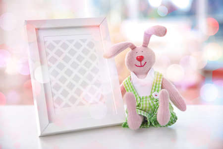 Photo frame and toy for baby on Christmas lights background. Holidays celebration conceptの写真素材