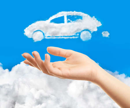 Female hand and car shape cloud on sky backgroundの写真素材