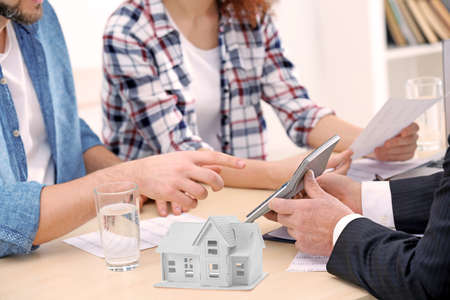 Real estate agent with clients on meeting in officeの写真素材