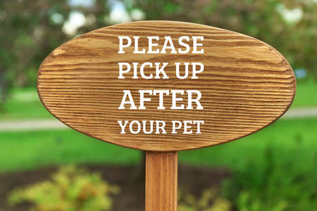 Signboard with text PLEASE PICK UP AFTER YOUR PET at parkの写真素材