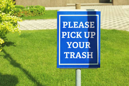 Signboard with text PLEASE PICK UP YOUR TRASH at parkの写真素材