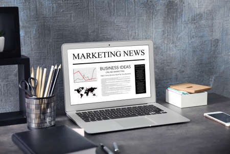 Office workplace with modern laptop. Marketing news on screenの写真素材