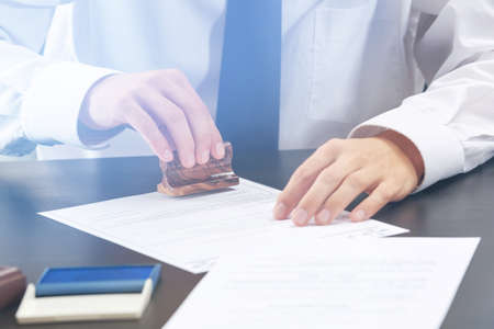 Notary public stamping document in officeの写真素材