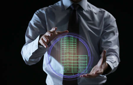 Real estate agent showing projection of building on dark backgroundの写真素材