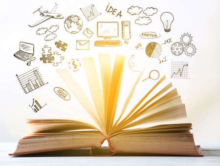 Open book and drawings on light background. School conceptの写真素材