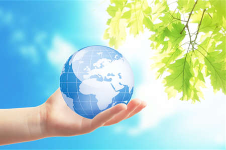 Little child holding globe in hand on sky background. Concept of aidの写真素材