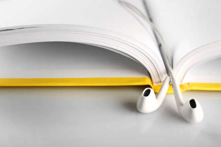 Earphones and book on table, closeupの写真素材