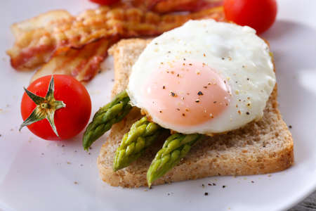 Dish of asparagus and egg in plate on table, closeupの写真素材