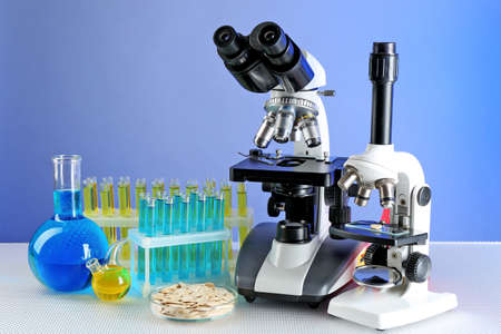 Microscopes, Petri dish with samples of grain and test tubes on table, on color backgroundの写真素材