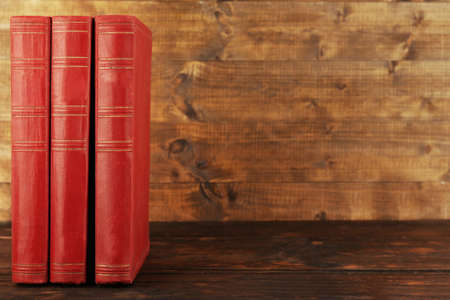 Books on wooden table on wooden wall backgroundの写真素材