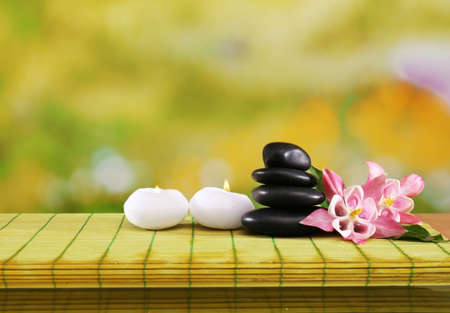 Spa still life with flowers and candlelight on green blurred backgroundの写真素材