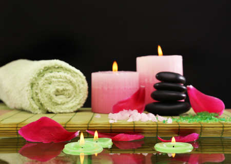 Spa still life with pink petals and candlelight on black backgroundの写真素材