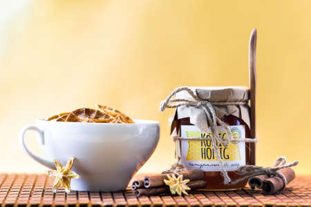 Honey lemon and tea with cinnamon. Wooden spoon is tied to the glass jarの写真素材