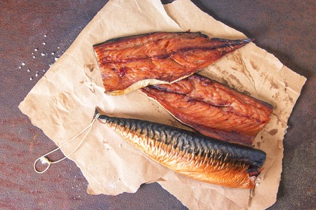 Smoked mackerel fillets on craft paper on a rustic rusty metal table. Top view.の写真素材