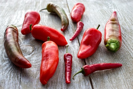 Various fresh hot red chilli pepper on wooden background.の写真素材