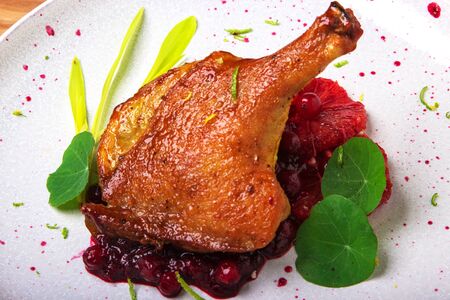 baked duck leg on red grapefruit with cranberry sauceの写真素材