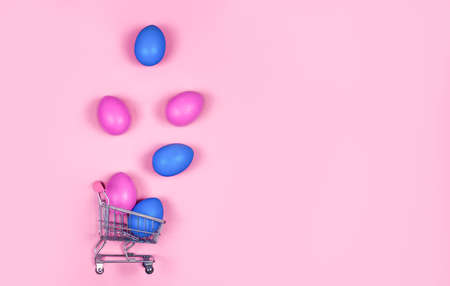 Banner on a pink background. The concept of online shopping for Easter, purchases and sale for the holiday. Gift bag with bunny ears and Easter eggsの写真素材