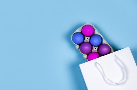 Banner on a blue background. The concept of online shopping for Easter, purchases and sale for the holiday. Gift bag with Easter eggsの写真素材