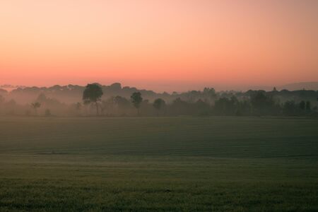 pink sunrise in a foggy countryside landscape in Vilob? d'Onyar in Gironaの写真素材
