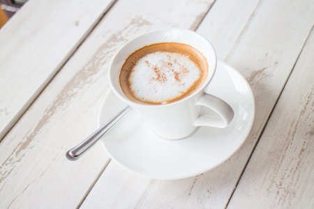 Coffee in a cup on a white wooden tableの写真素材