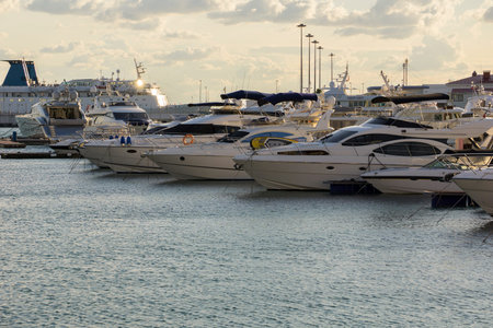 The yachts moored in the port are arranged in a row, of different models and types.