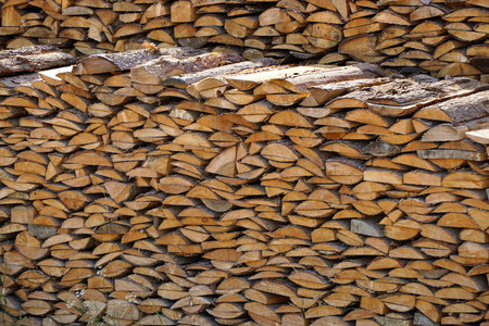 a stack of stacked firewood, harvested lumber, a lot of firewood of different shapes and types of...