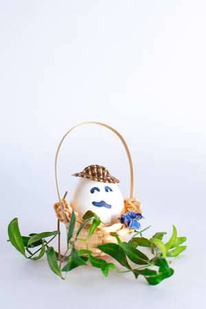 Basket with Easter eggs on white pastel background. Creative idea. Art food concept.の写真素材