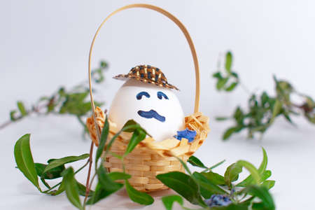 Basket with Easter eggs on white pastel background. Creative idea. Art food concept.の写真素材