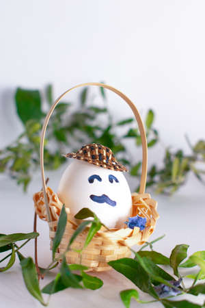 Basket with Easter eggs on white pastel background. Creative idea. Art food concept.の写真素材
