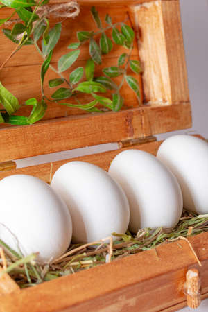 white eggs on straw in a wooden boxの写真素材