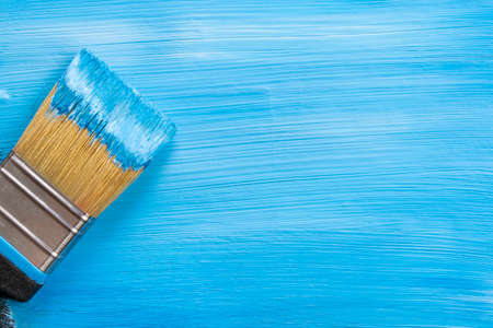 paint brush painting with blue color. close-up. Blue background. copy space. flat lay.の写真素材