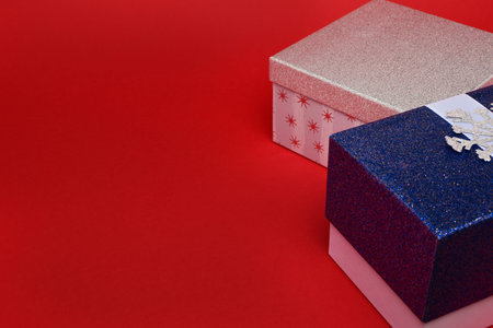 Red and white gift boxes in sparkles on a red background. New year concept, top view, copy space, minimal style.の写真素材