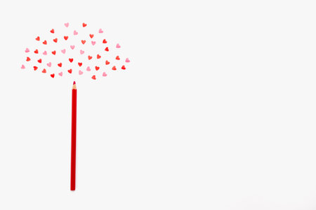 small sweet hearts lie in a semicircle over a red pencil on a white background. horizontal photo....