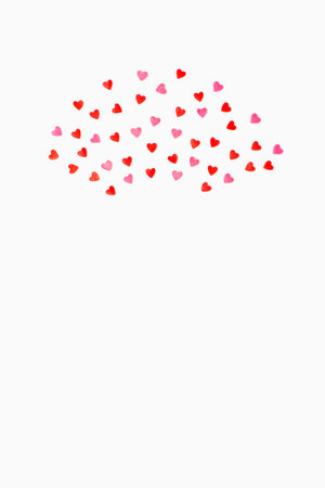 small sweet hearts lie in a semicircle on a white background. vertical photo. Flat lay. Copy space