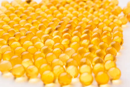 fish oil pills arranged on white background.の写真素材