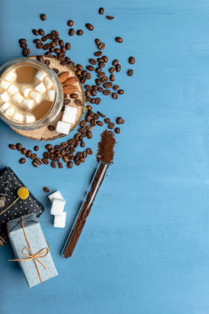 Mug Of Tea Or Coffee with marshmallows. Sugar And Spices. handful Of coffee baens. Christmas Decorations. blue or aqua backgroundの写真素材