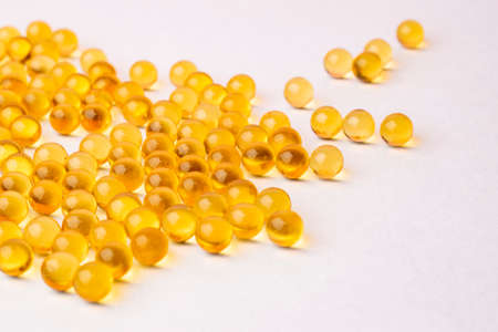 fish oil pills arranged on white background.の写真素材