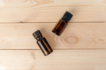 two glass bottles with aromatic oils on a light wooden background. Flat lay.の写真素材