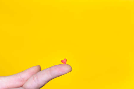Human hand holding one sweet candy heart.の写真素材