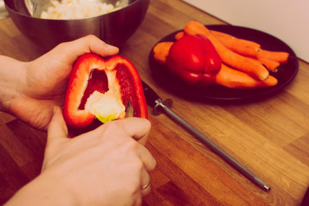 Man holding red, sweet pepper or paprika. Health and healthy lifesyle concept. Man cuts a red bell...
