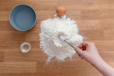A step-by-step process for preparing dumplings. View from above. Men's hands gradually mix the ingredients: flour, egg, water, oilの写真素材