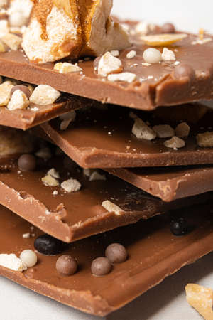 Close-up of a pyramid of delicious milk chocolate with nuts and waffle ballsの写真素材