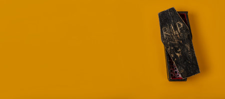 A yellow-colored halloween banner with a miniature homemade red-black coffin from which a lot of...
