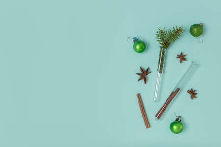 Christmas composition of test tubes, festive balls, cinnamon and star anise on a mint background with copy space. Top view, flat lay. Medical New Year conceptの写真素材